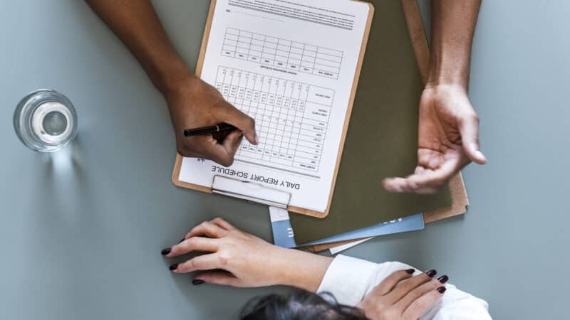 Aerial view of doctor writing patient daily report checklist